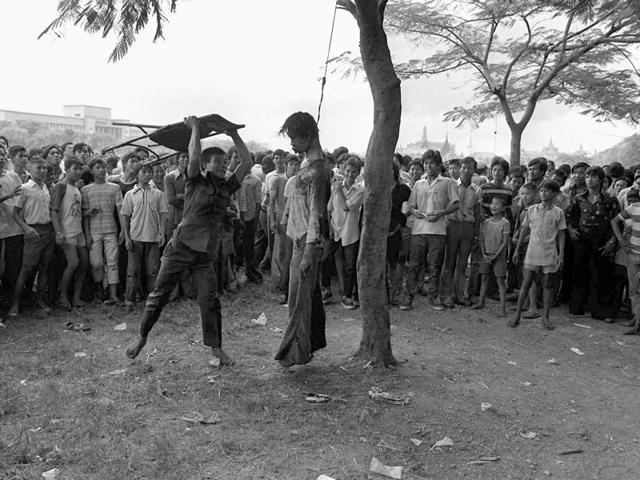 In this October 6, 1976 file photo a member of a Thai political faction strikes at the lifeless body of a hanged student outside Thammasat University in Bangkok . (Neal Ulevich/ AP File) In this October 6, 1976 file photo a member of a Thai political faction strikes at the lifeless body of a hanged student outside Thammasat University in Bangkok . (Neal Ulevich/ AP File)