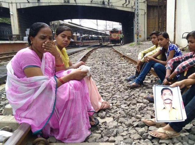The family of Deshraj Sen sit on rail tracks to demand probe into Sen’s disappearance, in Indore on Tuesday morning.(HT photo)