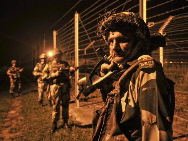 BSF soldiers stand guard during a night patrol near the fence at the India-Pakistan International Border at the outpost of Akhnoor sector, about 40 km from Jammu.(Nitin Kanotra/HT Photo)