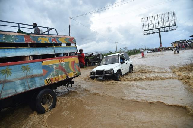 People try to cross the overflowing Rouyonne river in the commune of Leogane, south of Port-au-Prince. (AFP Photo) People try to cross the overflowing Rouyonne river in the commune of Leogane, south of Port-au-Prince. (AFP Photo)