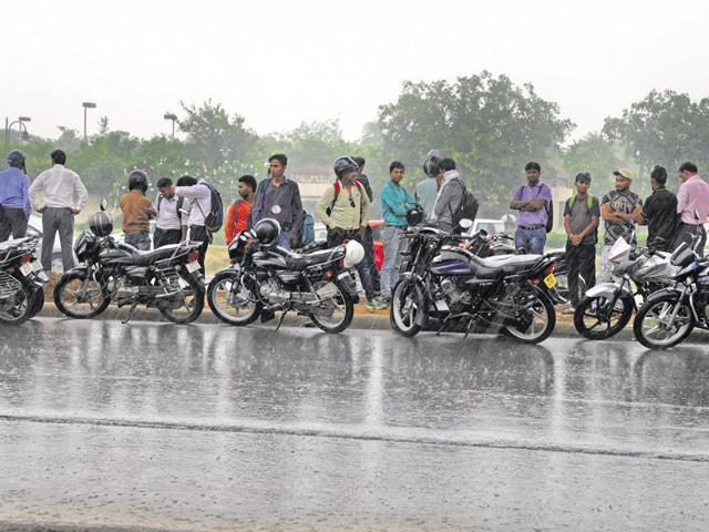 Taken by surprise, commuters wait out the rain in Gurgaon on Tuesday.(Parveen Kumar/HT Photo) Taken by surprise, commuters wait out the rain in Gurgaon on Tuesday.(Parveen Kumar/HT Photo)