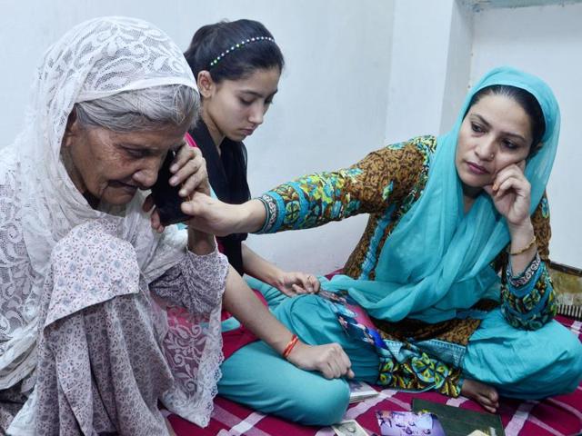 Suraiya Butt, with her granddaughter Saba Butt, daughter-in-law Tanveer Butt speaking to her daughter Shabnam Samriaz in Pakistan at her residence at Goal Hatti chowk in Amritsar on Tuesday.(Sameer Sehgal/HT Photo)