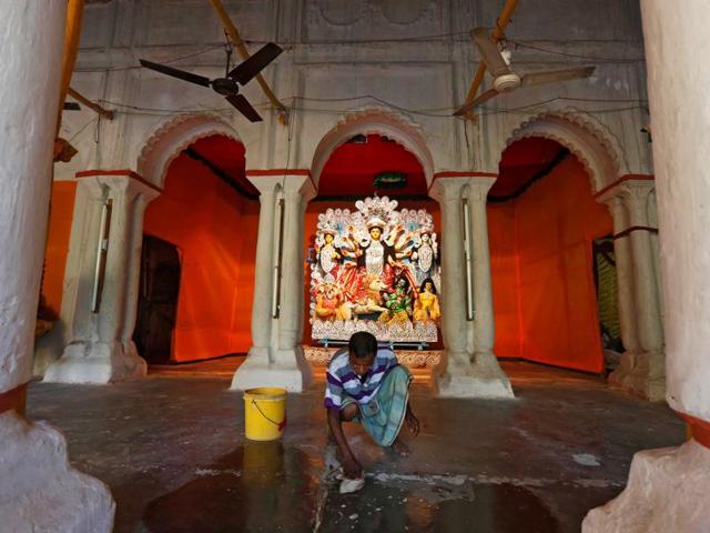 A worker cleans the floor after installing the idol of Goddess Durga at a platform inside a home in Kolkata, October 7, 2016. (REUTERS) A worker cleans the floor after installing the idol of Goddess Durga at a platform inside a home in Kolkata, October 7, 2016. (REUTERS)