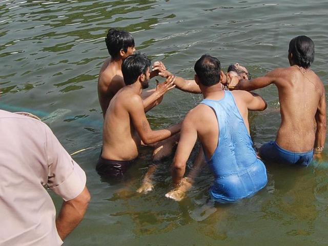 Sahil’s body being recovered from the temple sarovar in Amritsar on Saturday. (Gurpreet Singh/HT Photo)