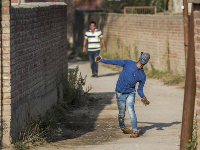 A protester throws rocks at government forces after the police stopped the funeral procession of Junaid Ahmed, a 12-year-old boy in Srinagar. (AP Photo) A protester throws rocks at government forces after the police stopped the funeral procession of Junaid Ahmed, a 12-year-old boy in Srinagar. (AP Photo)