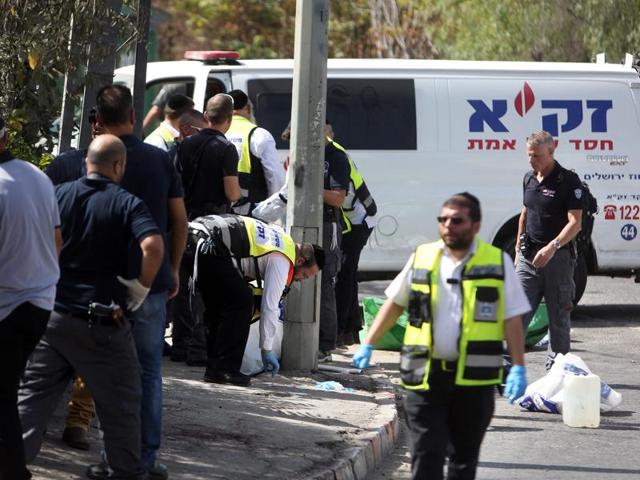 Zaka volunteers, an emergency response team in Israel, collect human remains at the site of a shooting attack near the Israeli police headquarters on Sunday. (AFP) Zaka volunteers, an emergency response team in Israel, collect human remains at the site of a shooting attack near the Israeli police headquarters on Sunday. (AFP)