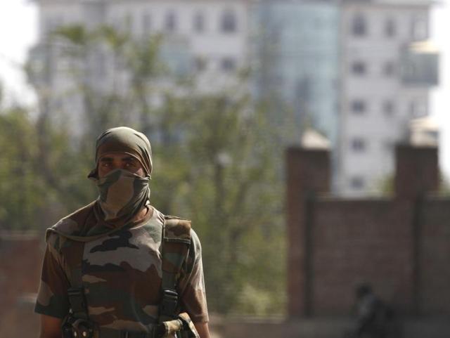 A soldier stands guard near the government building in Pampore where militants have taken refuge during a gun-battle. (Waseem Andrabi/HT Photo) A soldier stands guard near the government building in Pampore where militants have taken refuge during a gun-battle. (Waseem Andrabi/HT Photo)