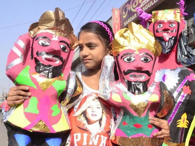 A gril holding the effigies on sale in Amritsar on Monday.  (Sameer Sehgal/HT Photo) 