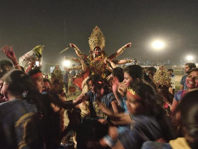 Devotees celebrate as they prepare to immerse an idols of Goddess Durga in River Yamuna. (Gurinder Osan/HT PHOTO)