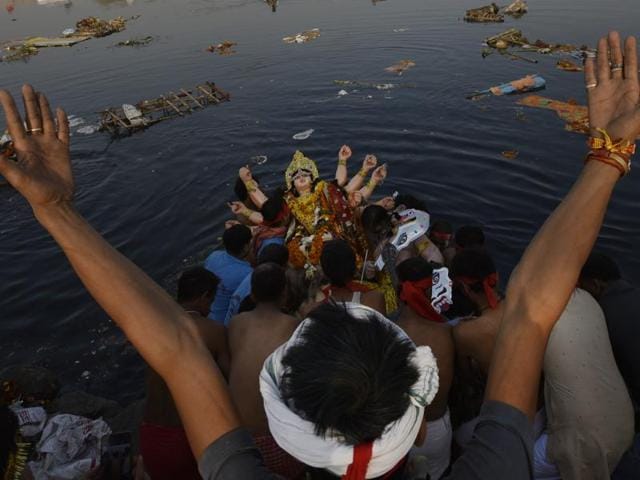 Devotees immersing idols of Goddess Durga in River Yamuna in New Delhi on Tuesday. (Ravi Choudhary/HT PHOTO)