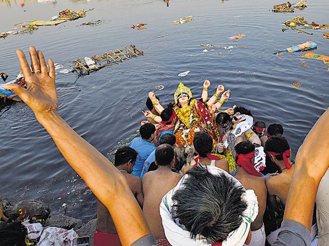 Hundreds of Durga idols were immersed at around seven Yamuna ghats across the national capital on Tuesday, with authorities trying to ensure that non-biodegradable items do not make it to the already polluted river. (Ravi Choudhary/Hindustan Times) Hundreds of Durga idols were immersed at around seven Yamuna ghats across the national capital on Tuesday, with authorities trying to ensure that non-biodegradable items do not make it to the already polluted river. (Ravi Choudhary/Hindustan Times)
