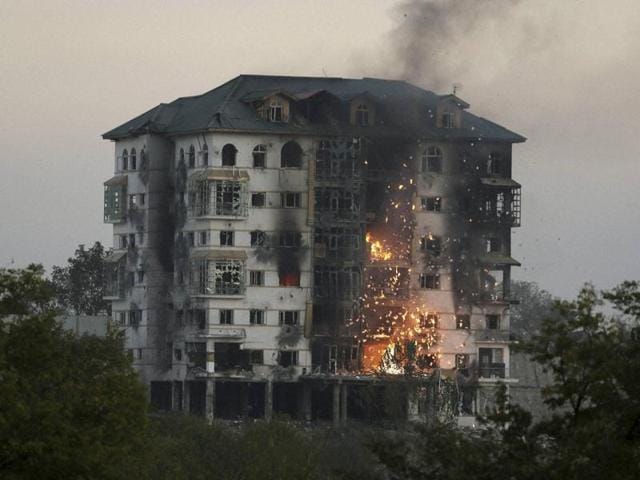 Fire and smoke rises from the government building where suspected militants are holed up in Pampore. (PTI Photo) Fire and smoke rises from the government building where suspected militants are holed up in Pampore. (PTI Photo)