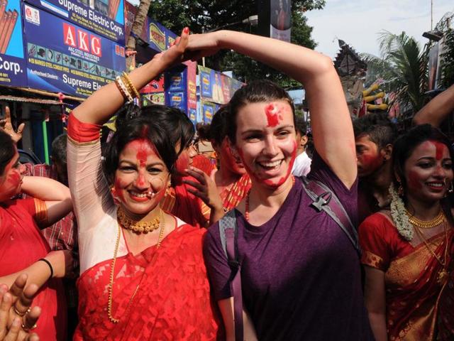 A foreigner takes part in the immersion procession of Durga idol in Kolkata on Tuesday. (Subhankar Chakraborty/HT PHOTO)