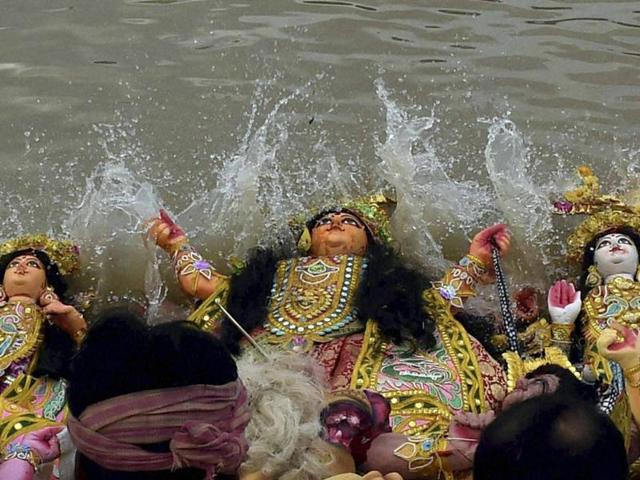 Devotees immersing the idol of Goddess Durga in the Ganga river in Kolkata on Tuesday. (PTI)