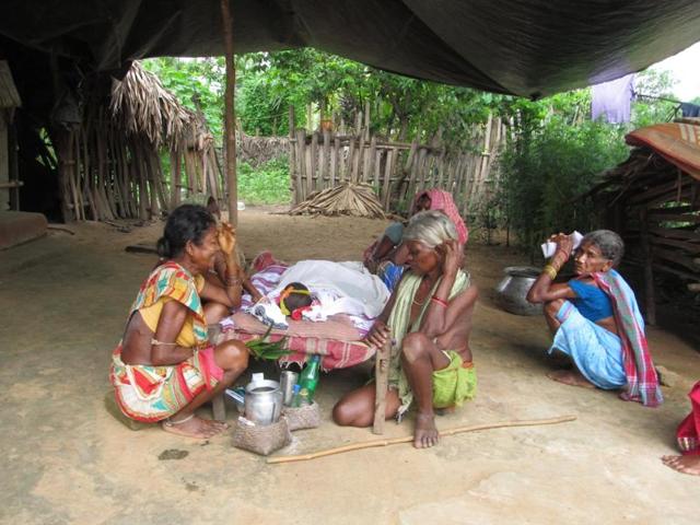 Relatives of a tribal kid who died of Encephalitis grieving near her body at a village in Malkangiri.(HT Photo)