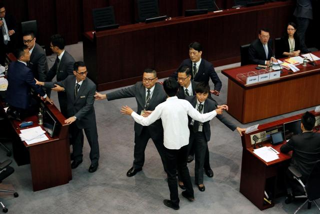 Pro-democracy lawmakers Eddie Chu (in white) and Raymond Chan are blocked by security guards as they try to stop the process of electing council chairman at the Legislative Council in Hong Kong. (REUTERS) Pro-democracy lawmakers Eddie Chu (in white) and Raymond Chan are blocked by security guards as they try to stop the process of electing council chairman at the Legislative Council in Hong Kong. (REUTERS)