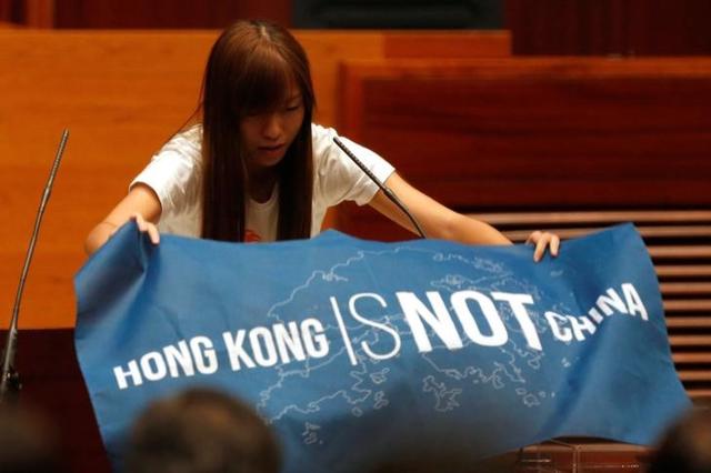 Newly elected lawmaker Yau Wai-ching displays a banner before taking oath at the Legislative Council in Hong Kong, China. (Reuters) Newly elected lawmaker Yau Wai-ching displays a banner before taking oath at the Legislative Council in Hong Kong, China. (Reuters)