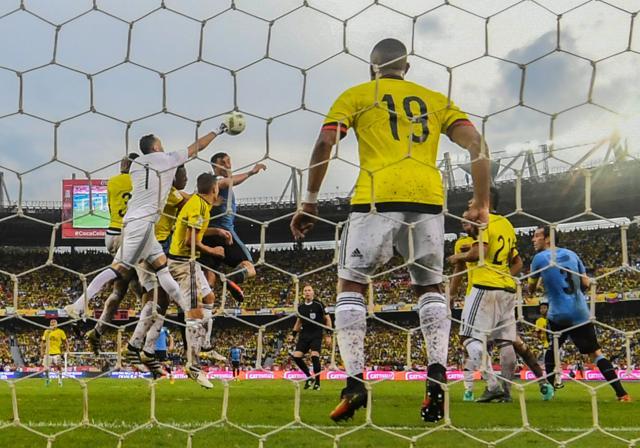 Colombia's goalkeeper David Ospina (1) tries to catch the ball over Uruguay's Cristian Rodriguez. (AFP Photo) Colombia's goalkeeper David Ospina (1) tries to catch the ball over Uruguay's Cristian Rodriguez. (AFP Photo)