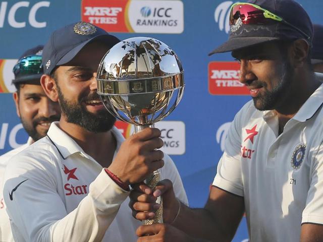 Indian cricket team captain Virat Kohli, left, and teammate Ravichandran Ashwin hold the ICC Test Championship mace at the end of their third test cricket match against New Zealand in Indore, India, Tuesday, Oct. 11, 2016.(AP)