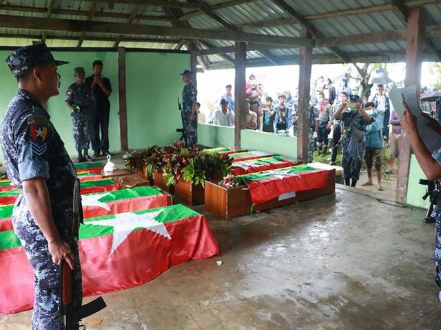 Myanmar border police prepare the flag draped coffins bearing nine bodies of border guards killed in mysterious raids during a funeral ceremony at a cemetery in Maungdaw in Rakhine on October 11, 2016.(AFP Photo)