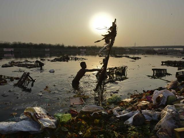 Locals scavenge for the remains of idols after Durga Puja immersion, in New Delhi. (Ravi Choudhary/HT Photo)
