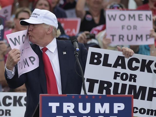 Republican presidential nominee Donald Trump kisses a "Women for Trump" placard during a rally at an airport in Lakeland, Florida on October 12, 2016. (AFP) Republican presidential nominee Donald Trump kisses a "Women for Trump" placard during a rally at an airport in Lakeland, Florida on October 12, 2016. (AFP)