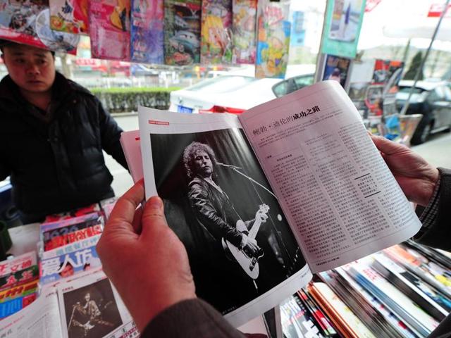 A customer browsing through a magazine with an image of Bob Dylan at a newsstand in Beijing.(AFP File Photo)