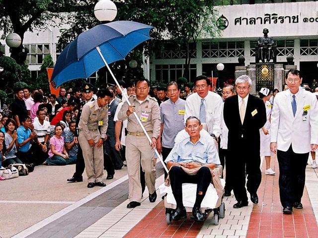 This file handout released by Thailand's Royal Bureau on October 23, 2009 shows well-wishers kneeling before Thai King Bhumibol Adulyadej as he sits in a wheelchair during an appearance at a hospital in Bangkok. (AFP)
