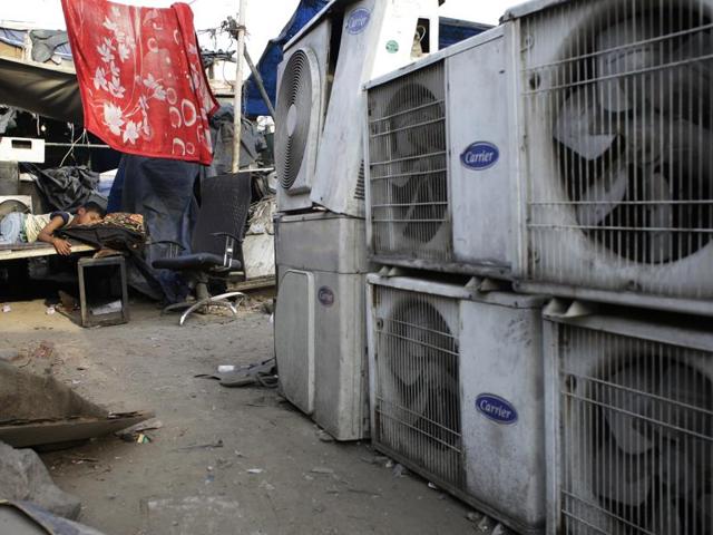 In this file photo, a boy sleeps near an air conditioner shop at a marketplace in New Delhi. Nations reached a deal Saturday to limit the use of hydrofluorocarbons, or HFCs - greenhouse gases far more powerful than carbon dioxide that are used in air conditioners and refrigerators, in a major effort to fight climate change.(AP File Photo)