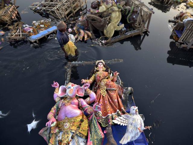 Locals scavenge for the valuable or useful remains amid idols of goddess Durga in river Yamuna near ISBT in New Delhi on October 12, 2016. (Ravi Choudhary/HT PHOTO) Locals scavenge for the valuable or useful remains amid idols of goddess Durga in river Yamuna near ISBT in New Delhi on October 12, 2016. (Ravi Choudhary/HT PHOTO)