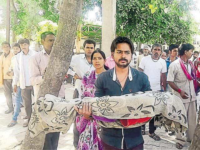 Pawan Namdev with the body of his six-year-old son Anuj in Bhind. (HT Photo) Pawan Namdev with the body of his six-year-old son Anuj in Bhind. (HT Photo)