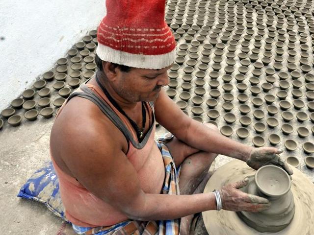 A woman makes diyas on her potter wheel ahead of Diwali in Indore.(Arun Mondhe / HT photo)