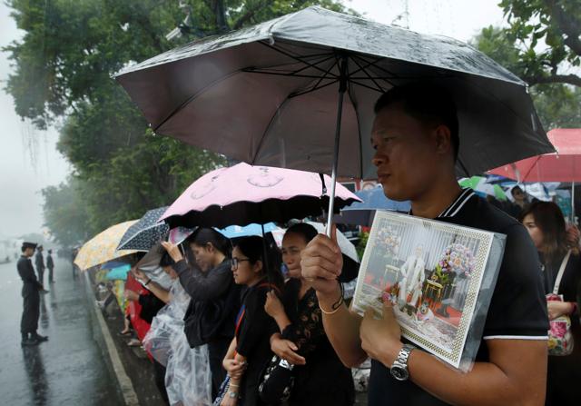 Mourners gather in the rain outside the Grand Palace as they wait to pay their respects to the late King Bhumibol Adulyadej in Bangkok, Thailand on Sunday. (REUTERS) Mourners gather in the rain outside the Grand Palace as they wait to pay their respects to the late King Bhumibol Adulyadej in Bangkok, Thailand on Sunday. (REUTERS)