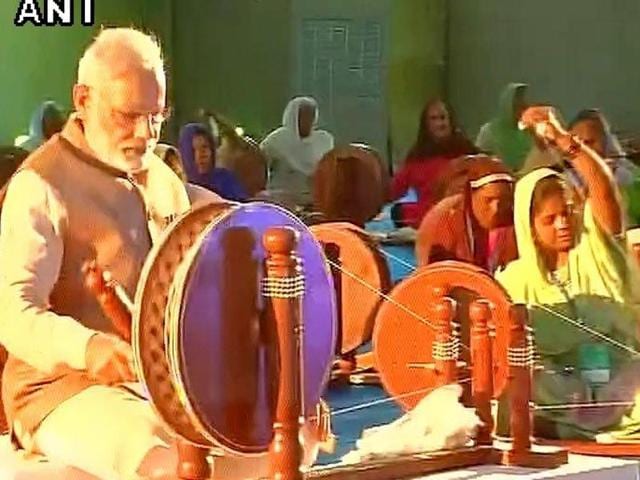 Narendra Modi trying his hand on the spinning wheel. (Photo: ANI) Narendra Modi trying his hand on the spinning wheel. (Photo: ANI)