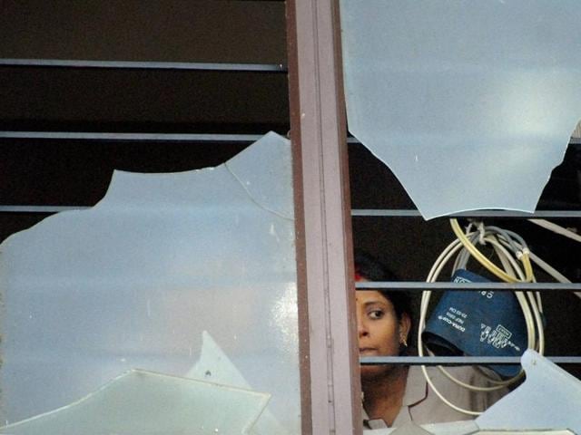 A nurse peeps out from the broken window of Bhubanewar’s SUM Hospital where a fire on Monday night killed 21 people. (PTI) A nurse peeps out from the broken window of Bhubanewar’s SUM Hospital where a fire on Monday night killed 21 people. (PTI)