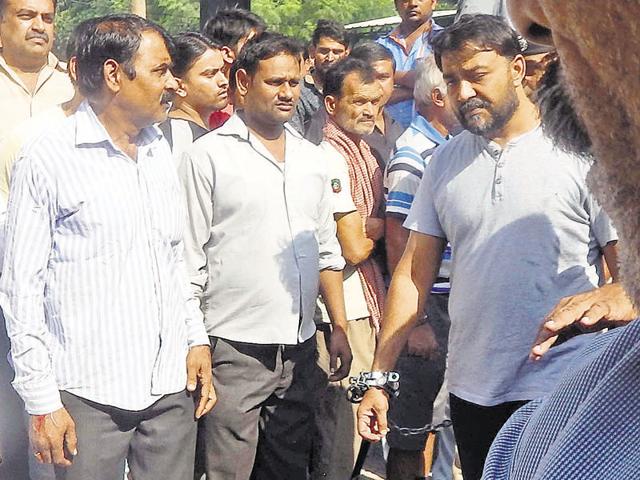 Binder Gujjar (in handcuffs), elder to Manoj and younger to Manish, is serving a jail term after being arrested in November for the murder of a rival gang member.(HT Photo) Binder Gujjar (in handcuffs), elder to Manoj and younger to Manish, is serving a jail term after being arrested in November for the murder of a rival gang member.(HT Photo)
