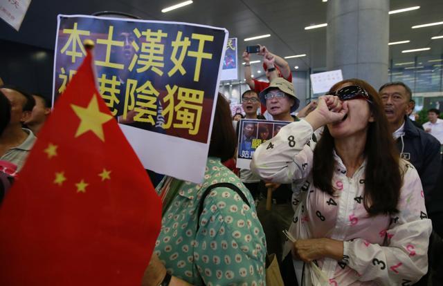 Pro-Beijing supporters hold a Chinese flag and placard depicting legislator-elect Sixtus Leung outside the Legislative Council in Hong Kong on Wednesday. (AP) Pro-Beijing supporters hold a Chinese flag and placard depicting legislator-elect Sixtus Leung outside the Legislative Council in Hong Kong on Wednesday. (AP)