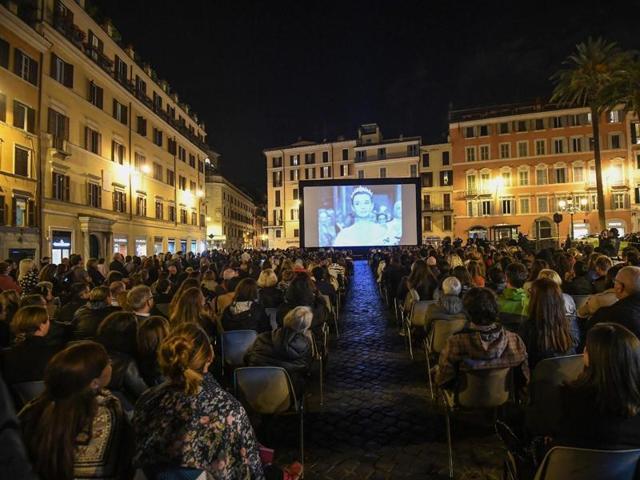 People watch the film Roman Holiday, the 1953 movie starring Gregory Peck and Audrey Hepburn, next to the Spanish Steps, on the occasion of the celebrations of the centenary of the birth of actor Gregory Peck, in Rome. (AP)
