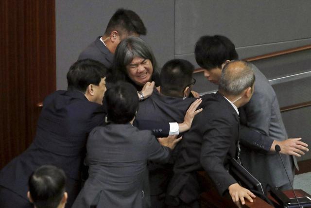 Newly elected pro-democracy lawmaker Raymond Chan Chi-chuen tries to break through the security guards during the election of president of the Legislative Council in Hong Kong on Wednesday. (AP) Newly elected pro-democracy lawmaker Raymond Chan Chi-chuen tries to break through the security guards during the election of president of the Legislative Council in Hong Kong on Wednesday. (AP)