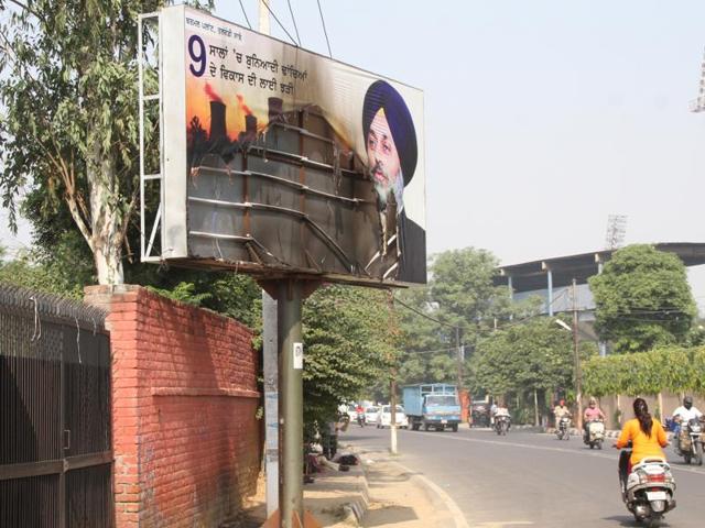 A burnt hoarding of deputy chief minister Sukhbir Badal near Durga Mata Mandir on Club Road in Ludhiana on Tuesday.(JS Grewal/HT Photo) A burnt hoarding of deputy chief minister Sukhbir Badal near Durga Mata Mandir on Club Road in Ludhiana on Tuesday.(JS Grewal/HT Photo)
