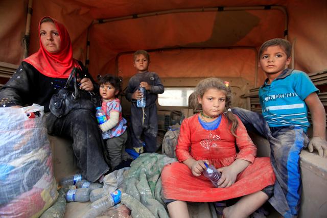 Displaced people who are fleeing from clashes sit at a military vehicle in Qayyarah, during an operation to attack Islamic State militants in Mosul. (REUTERS) Displaced people who are fleeing from clashes sit at a military vehicle in Qayyarah, during an operation to attack Islamic State militants in Mosul. (REUTERS)
