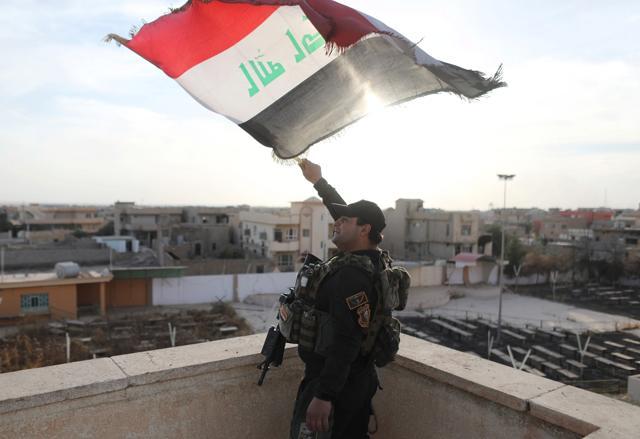 An Iraqi special forces soldiers waves an Iraqi flag from top of a church damaged by Islamic States fighters in Bartella, east of Mosul, Iraq, October 21. 2016. (REUTERS) An Iraqi special forces soldiers waves an Iraqi flag from top of a church damaged by Islamic States fighters in Bartella, east of Mosul, Iraq, October 21. 2016. (REUTERS)