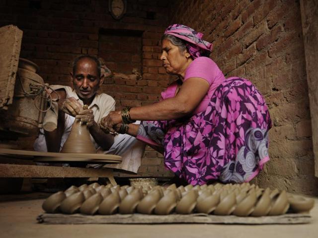 Though wax candles and electric lights have outdone the earthen lamps  in illuminating homes on Diwali, many potters’ families are still keeping the tradition alive hoping that these will make a comeback. (Burhaan Kinu/HT PHOTO) 