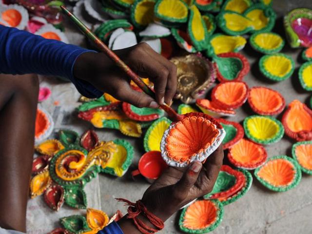 The coloured diyas are painted at Dakshindari in North Kolkata. (Subhendu Ghosh / HT PHOTO)