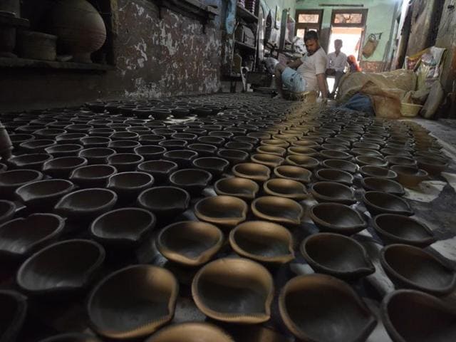 As the demand spikes during Diwali, potters churn out more diyas. Roadside stalls crop up in many markets just selling diyas and candles. (Sanjeev Verma/HT Photo)
