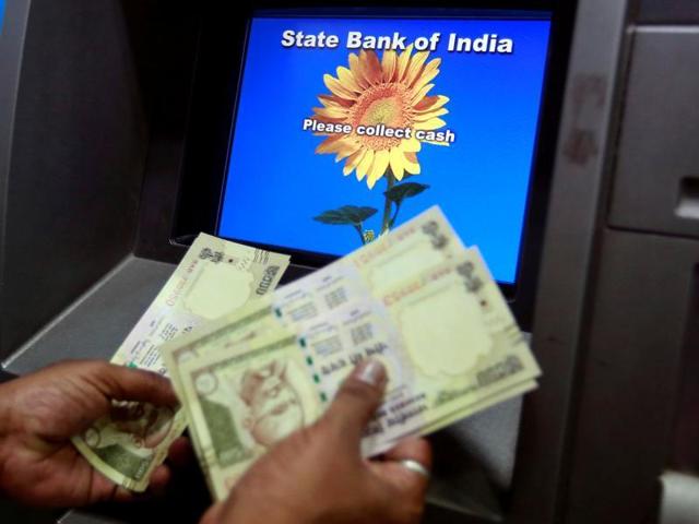 A man counts money after withdrawing it from a State Bank of India ATM.(REUTERS) A man counts money after withdrawing it from a State Bank of India ATM.(REUTERS)