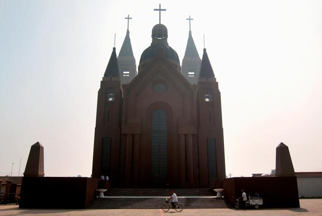 A man rides his bicycle past the steps of a large Catholic church in the village of Bai Gu Tun, located on the outskirts of the city of Tianjin, around 70 km (43 miles) south-east of Beijing July 17, 2012. (Reuters) A man rides his bicycle past the steps of a large Catholic church in the village of Bai Gu Tun, located on the outskirts of the city of Tianjin, around 70 km (43 miles) south-east of Beijing July 17, 2012. (Reuters)