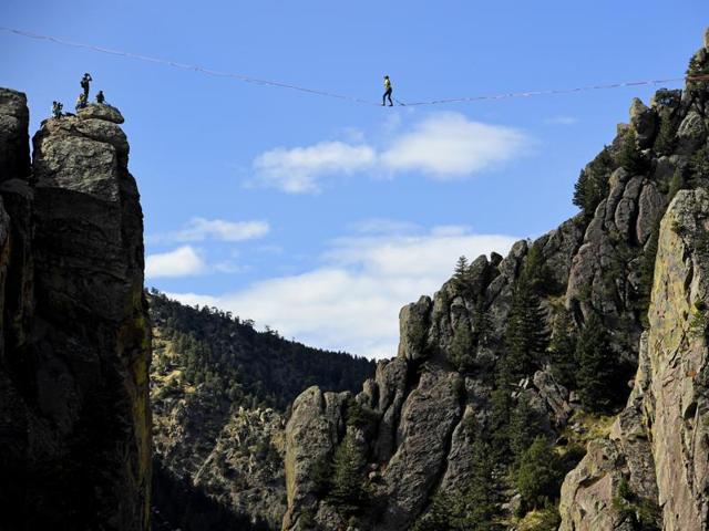 Taylor VanAllen, 24, makes the First Across, or FA, on a high-line from the Wind Tower rock formation to the Bastille rock formation, 450 feet off the ground, in Boulder, Colorado. VanAllen, an athlete with Slackline Industries, recreated the Ivy Baldwin high line crossing of Eldorado Canyon in a benefit for trail building at the state park. (AP)