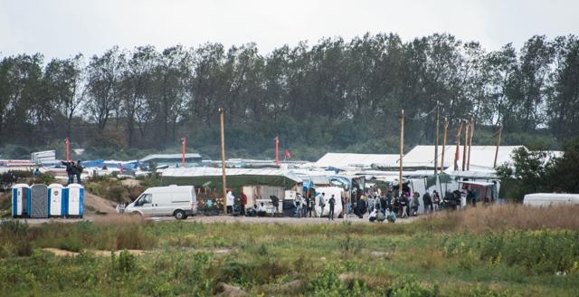 Migrants and refugees gather at the entrance of the 'Jungle' migrant camp. (AFP) Migrants and refugees gather at the entrance of the 'Jungle' migrant camp. (AFP)
