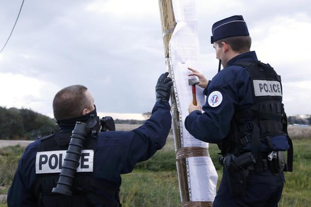 French police post the official document that announces the dismantling of the makeshift camp called the "Jungle”. (REUTERS) French police post the official document that announces the dismantling of the makeshift camp called the "Jungle”. (REUTERS)